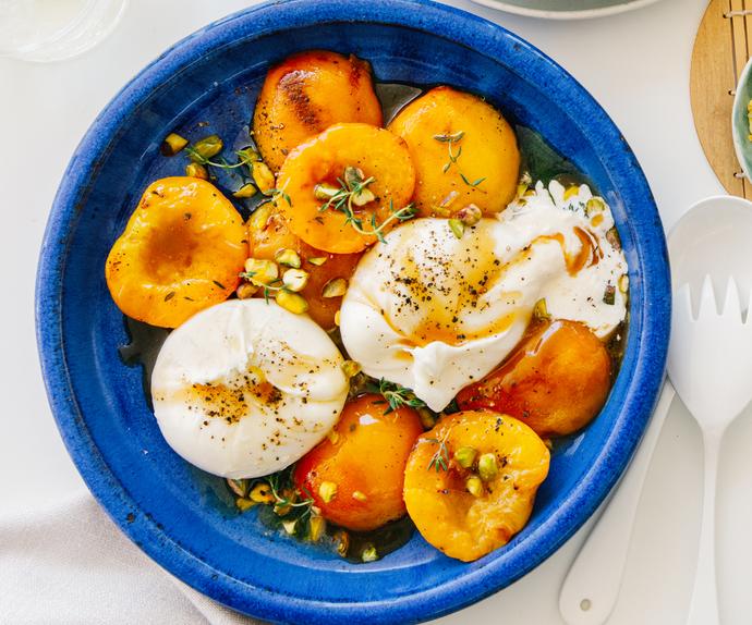 peach burrata salad of roast yellow peaches and burrata cheese in bright blue ceramic bowl