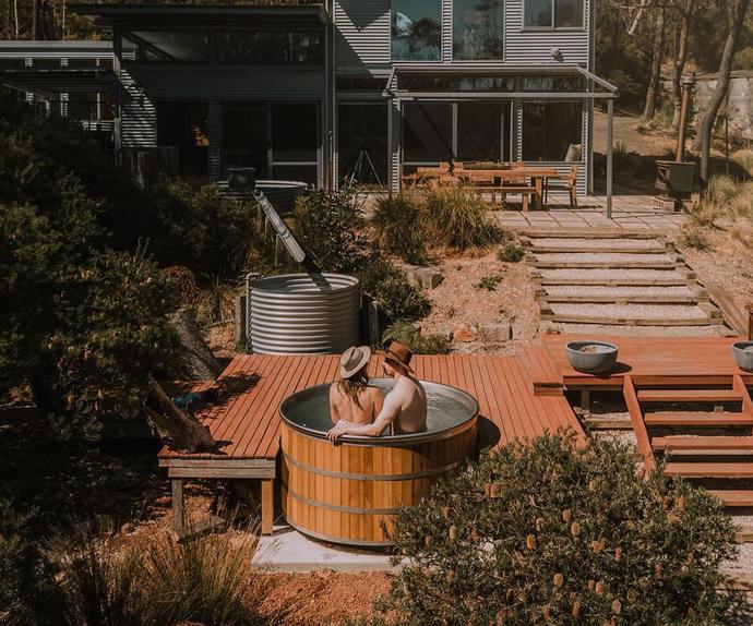 Two people in Wildacre's outdoor cedar hot tub in Blackheath.