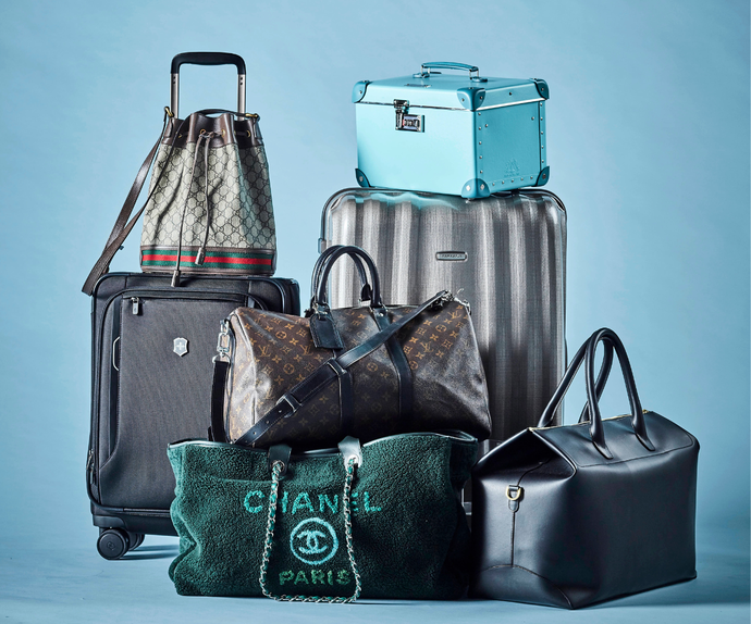 Best hard suitcase Australia - photo of An artful pile of suitcases with a blue background.